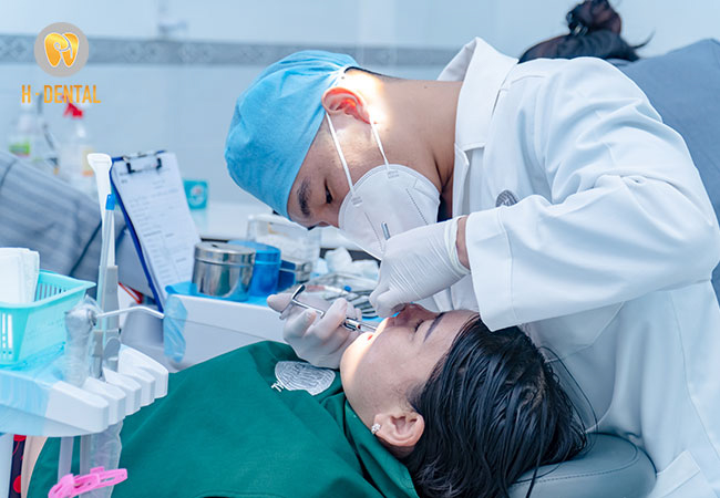 Bác sĩ tại Nha khoa H Dental Đồng Xoài đang thăm khám bệnh cho bệnh nhân